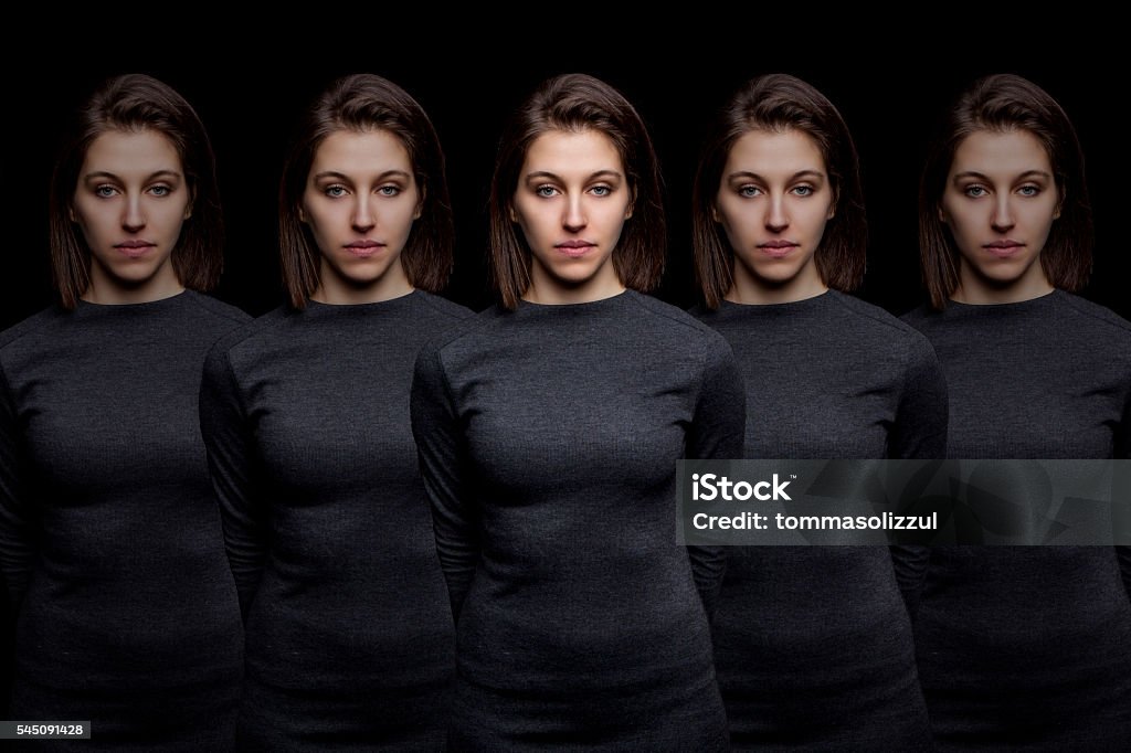 Group of young pretty women clones standing in a row Repetition Stock Photo