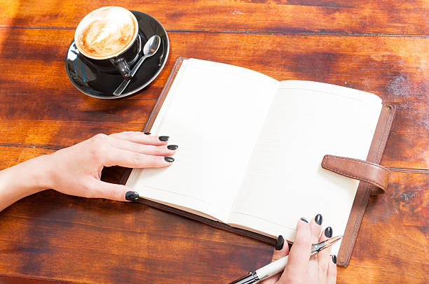 istock Woman hands with open notebook outside with coffee 545093390