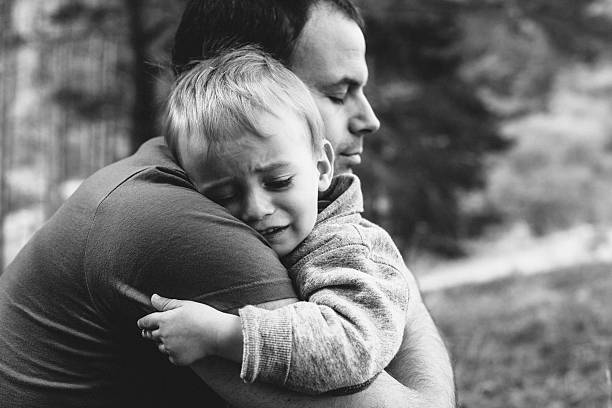 Father hugging his crying son Little boy crying on father's shoulder mercy hug stock pictures, royalty-free photos & images