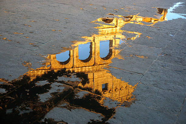 The reflection of Colosseum in a puddle, Rome, Italy