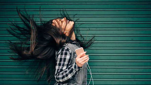 Young woman tossing hair while enjoying the music