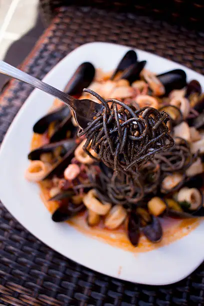 Squid ink black spaghetti in a spicy fra diavolo sauce with mussels, clams, calamari, and scallops. 