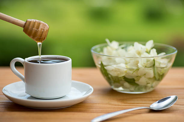 istock Honey drops from a honey dipper in glass cup with tea 545102172