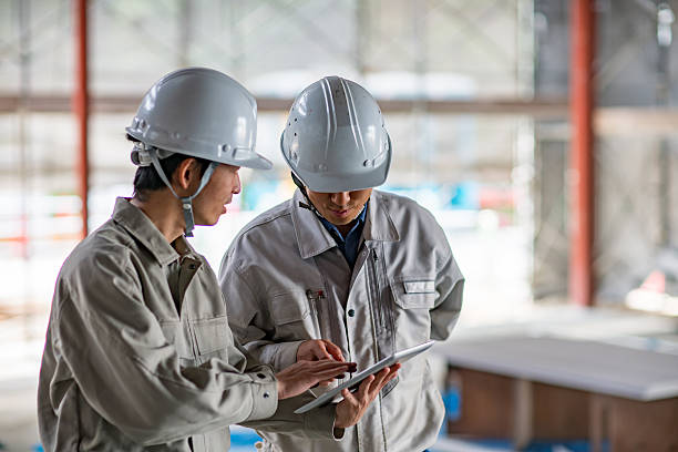 Two engineers looking at a digital tablet at building site stock photo