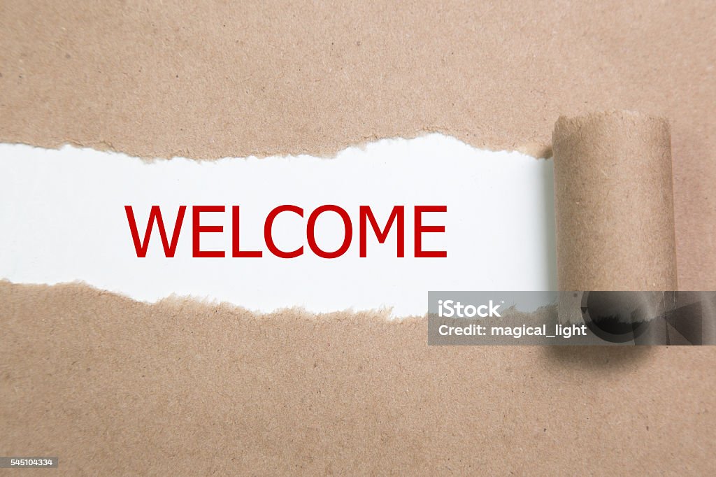 The text WELCOME behind torn brown paper Art And Craft Stock Photo