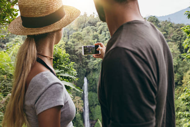 istock Young couple taking a picture of water fall 545110766