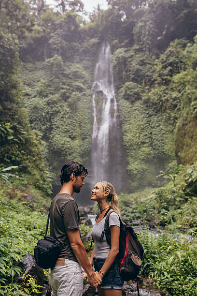 istock Couple in love standing near a waterfall in forest 545112554