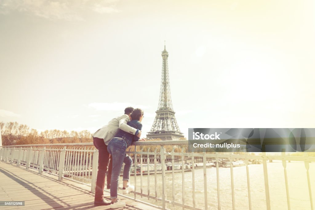 Multi-ethnic couple having fun in Paris near Eiffel Tower Multi-ethnic couple enjoying their trip to Paris along the Seine river, near Eiffel Tower. Eiffel Tower - Paris Stock Photo