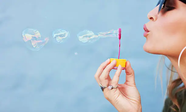 Photo of Young female blowing soap bubbles