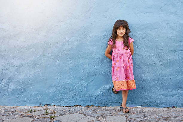 Portrait of cute little Indian girl model, standing isolated over white background