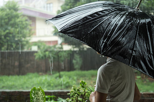 garçon avec parapluie à l’extérieur - color image season people wet photos et images de collection