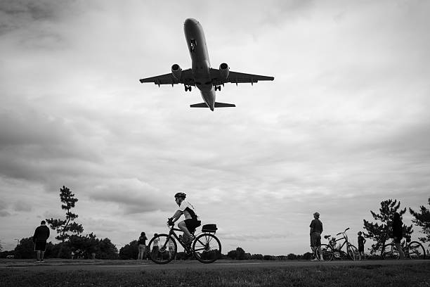 Watching planes land at Reagan National Airport Arlington, Virginia, USA - July 3, 2016: At Gravelly Point in Arlington, Virginia, an American Eagle jet passes over cyclists and other people moments before touching down at Ronald Reagan Washington National Airport. arlington virginia photos stock pictures, royalty-free photos & images