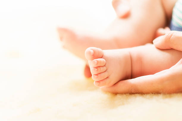 istock Mother holding baby feet 545116210