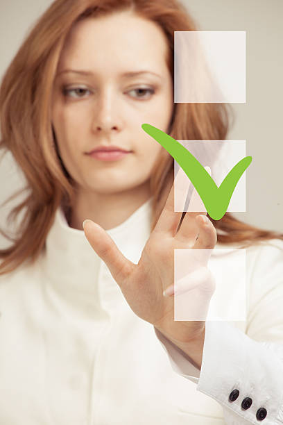 istock Young business woman checking on checklist box. Gray background. 545119694