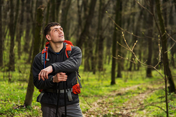 escursionista che indossa zaino da trekking e giacca durante un'escursione nella foresta. - hardshell foto e immagini stock