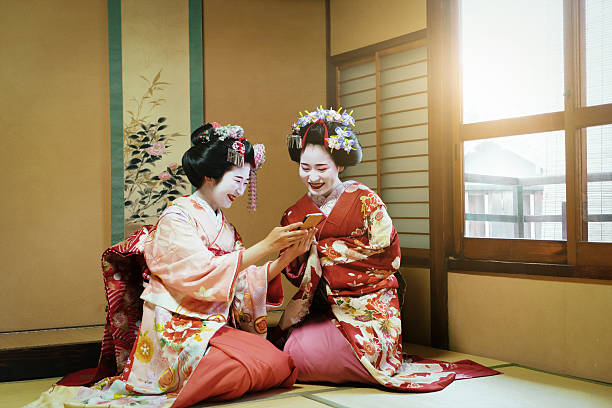 Young Maiko Having Fun Together With Smartphone Young Maiko Having Fun Together With Smartphone modern geisha stock pictures, royalty-free photos & images