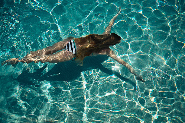 Woman swimming on a blue water pool