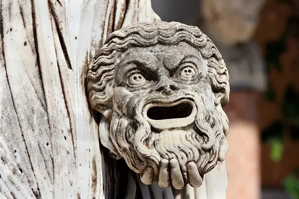 A tragic mask in the hand of Statue of Melpomene, the muse of tragedy, on the balcony of Achillion princess Sissy's palace on greek island Corfu in Greece.