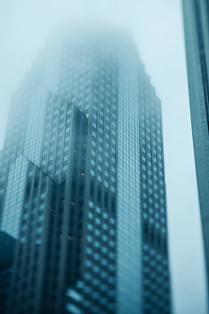 istock Large office buildings in fog from streel level 545125506