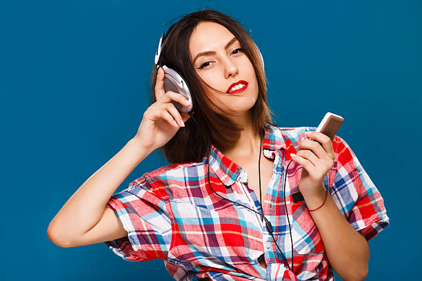 istock Passionate girl posing with headphones on blue background 545125826