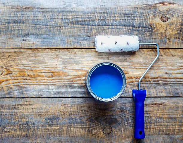 painting with can of blue paint and roller top view