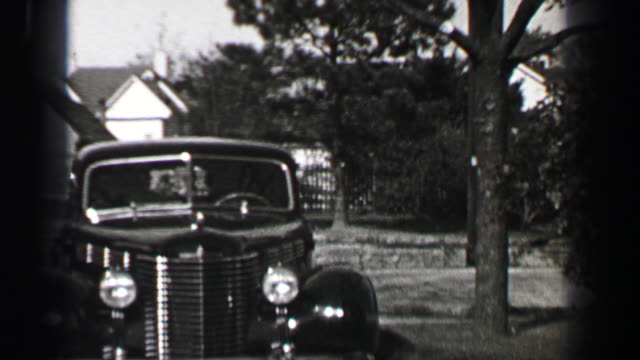 1939: Pontiac 4 door sedan car backing out of driveway front hinged rear door technology.