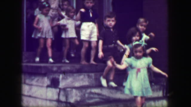 1949: School children leaving class down steep slippery concrete staircase, no handrail.