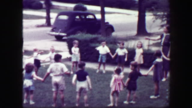 1949: Schoolmarm teacher playing Hooky Pooky childhood game in house front yard.
