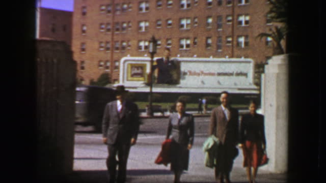 1957: Family walking 50s style advertisement billboard background.
