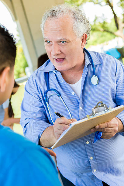 istock Senior Doctor filling out paperwork with patient 545248042