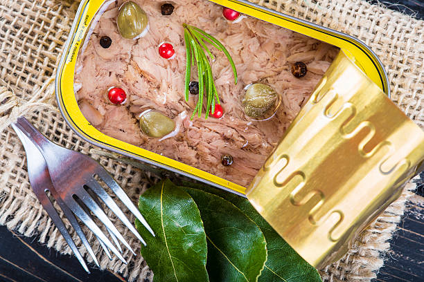 Light tuna in olive oil canned Light tuna in olive oil canned dressed with herbs and spices on a burlap and a wooden background heathy snack stock pictures, royalty-free photos & images