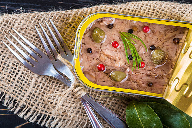 Light tuna in olive oil canned Light tuna in olive oil canned dressed with herbs and spices on a burlap and a wooden background heathy snack stock pictures, royalty-free photos & images