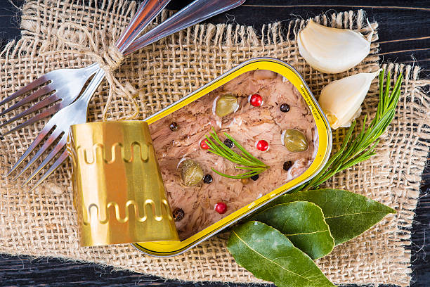 Light tuna in olive oil canned Light tuna in olive oil canned dressed with herbs and spices on a burlap and a wooden background heathy snack stock pictures, royalty-free photos & images