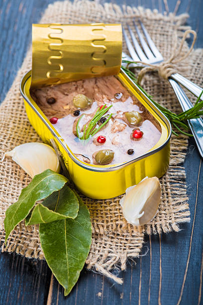 Light tuna in olive oil canned Light tuna in olive oil canned dressed with herbs and spices on a burlap and a wooden background heathy snack stock pictures, royalty-free photos & images