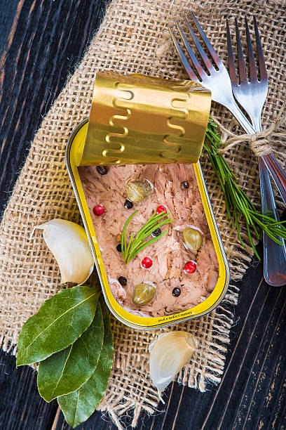 Light tuna in olive oil canned Light tuna in olive oil canned dressed with herbs and spices on a burlap and a wooden background heathy snack stock pictures, royalty-free photos & images