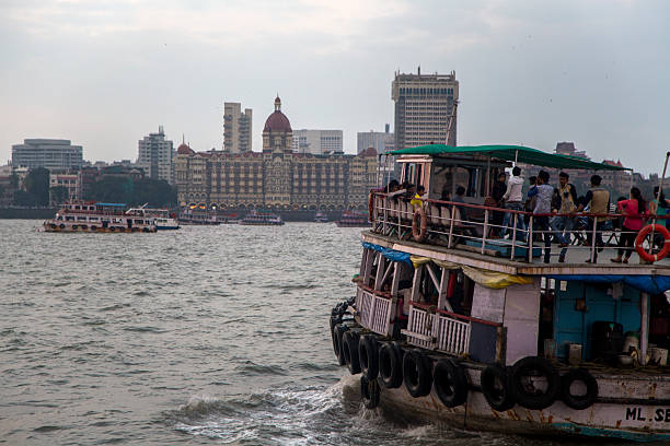Mumbai, India - October 11, 2015: Boat in front of the Taj Mahal Palace Hotel. This 5 star hotel is considered the flagship property of the group and contains 560 rooms and 44 suites. There are around 1,500 staff including 35 butlers.