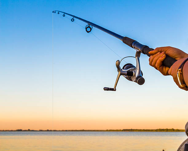 Fisherman fishing rod on the sunset close-up