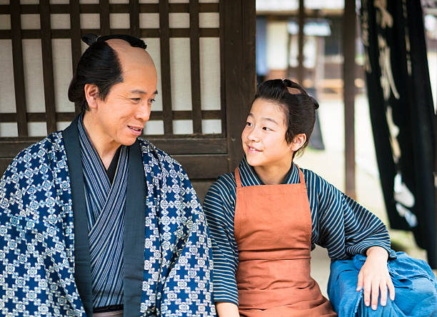 istock Man and boy talking while resting on old street, Japan 545261512