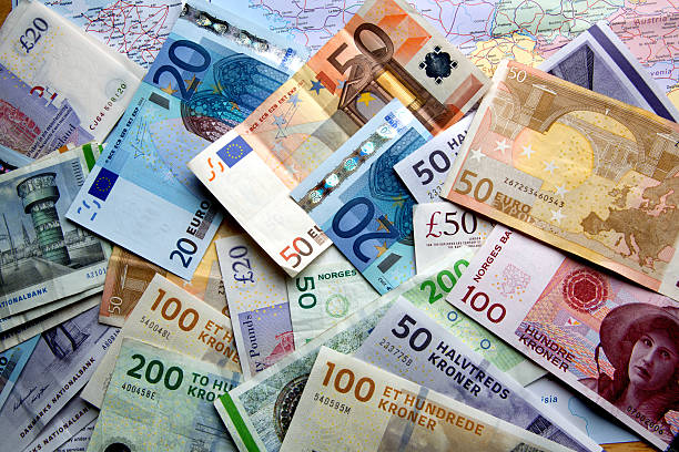 Foreign Currency Scattered Over A Map Map open to European countries with foreign currency scattered on top. french currency photos stock pictures, royalty-free photos & images