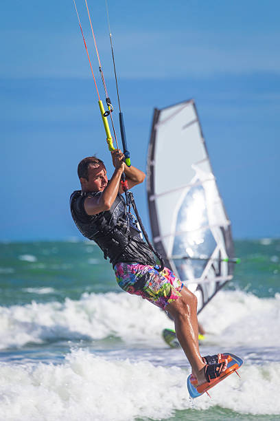istock Athletic man riding on kite surf board sea waves 545261966