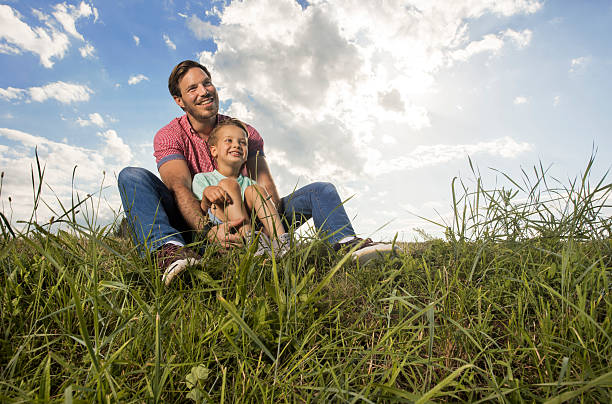 istock Young smiling father relaxing with his son on a meadow. 545262820