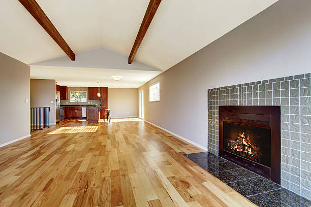 istock Empty room interior with hardwood floor, vaulted ceiling and fireplace 545265750
