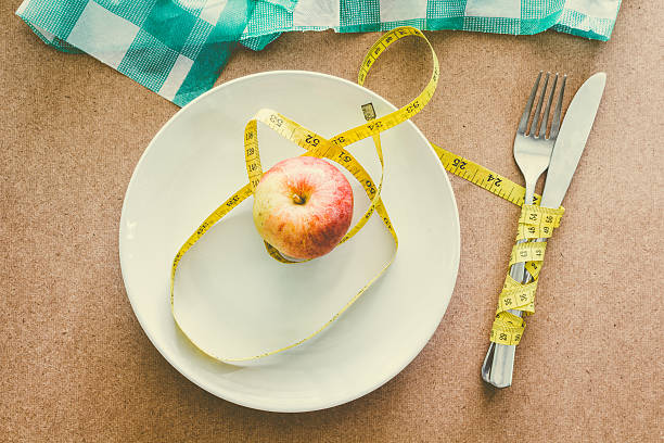 istock Apple with tape measure over plate on wooden table 545266000