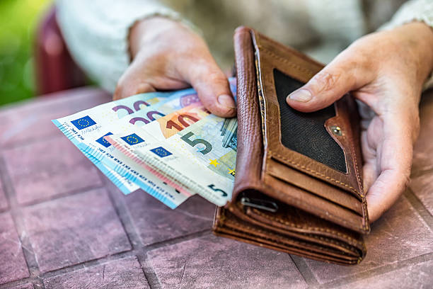 mujer pensionista que sostiene en la mano la billetera con dinero - women poverty senior adult mature adult fotografías e imágenes de stock