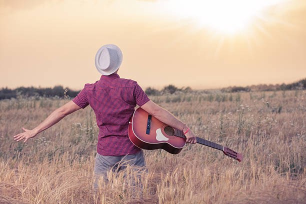 istock Young man with acoustic guitar enjoying the sunset 545270924