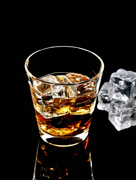 istock Whiskey with ice in glass isolated on black background 545271752