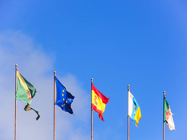 Five flags in a row on blue sky stock photo