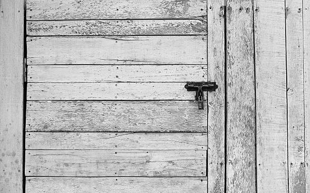 istock Old wooden plank vertical and horizontal door with padlock 545272688