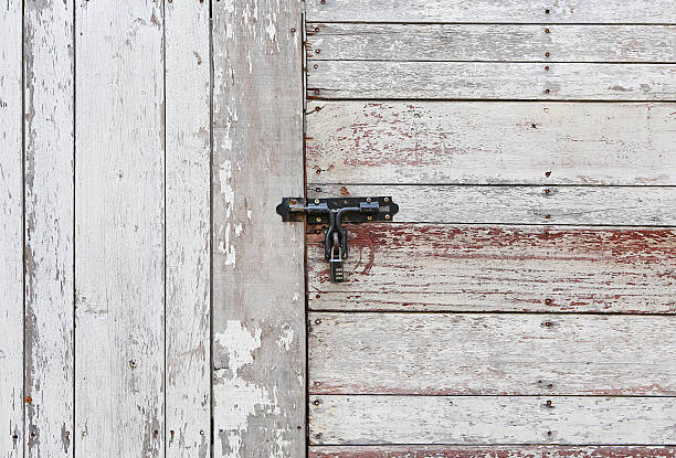 istock Old wooden plank vertical and horizontal door with padlock 545273082