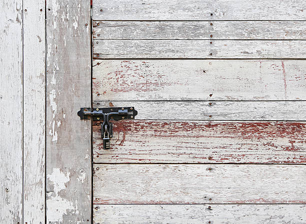 istock Old wooden plank vertical and horizontal door with padlock 545273220